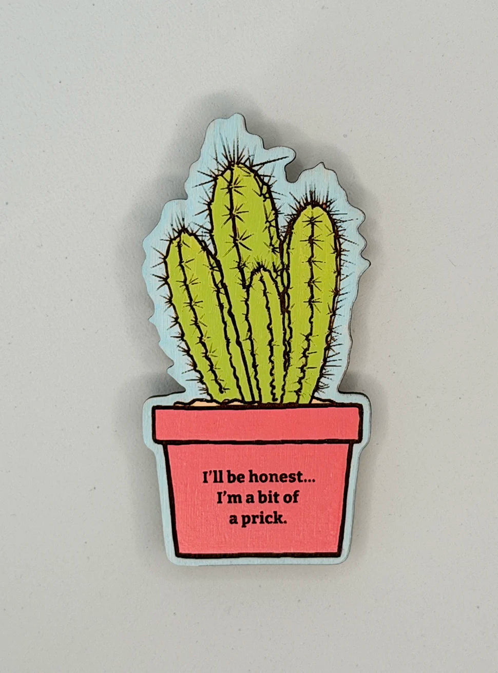 Small light engraved illustrated magnet showing a light green cactus in a bright coral pot with the words 'I'm honest... I'm a bit of a prick.' on the pot. The background of the image is a pale sky blue.